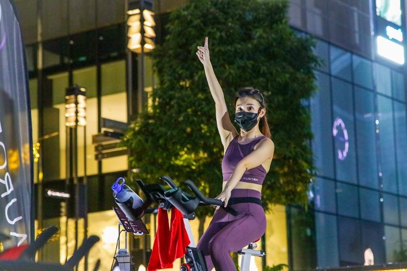 woman on stationary bicycle outdoors at night for spin class