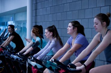 women on stationary bikes in gym