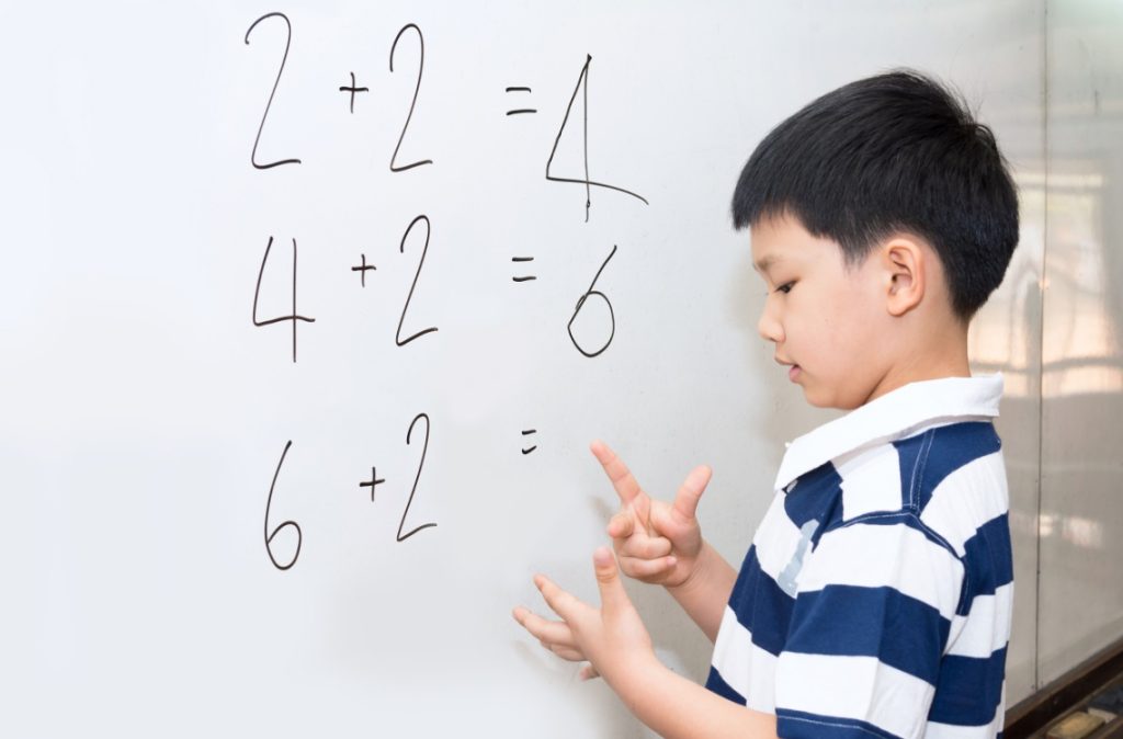 young boy looking at mathematic questions
