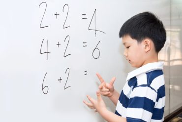 young boy looking at mathematic questions